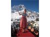 In traditional Austrian dress, a Austrian hotel manager 
                        shows off her village of Zurs, Austria