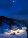 Snow Groomers working under moon over Loon Mountain.