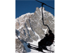 Skiers in chairlift with Mont Blanc in background